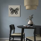 Chambre moderne avec art des papillons en noir et blanc, table sombre, plantes et suspension.