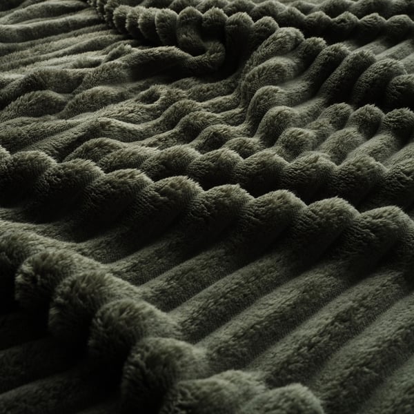 Couverture verte, douce et moelleuse en gros plan. Texture profonde, sensation de luxe.