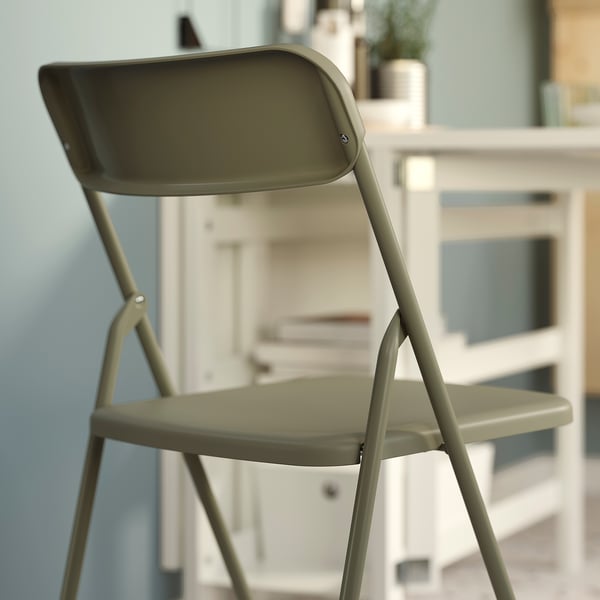 Une chaise pliante verte, exposée à l’état ouvert, idéale pour un usage intérieur.