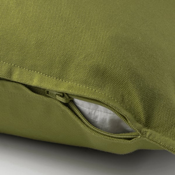 Une housse de coussin verte avec une fermeture éclair cachée, facile à enlever et fabriquée tout en coton.