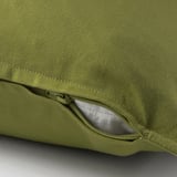 Une housse de coussin verte avec une fermeture éclair cachée, facile à enlever et fabriquée tout en coton.