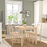 Ensemble de salle à manger en bois clair HÄGERNÄS avec table et 4 chaises, près de la fenêtre, cuisine confortable, chaises rustiques simples.