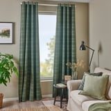 Salon avec des rideaux HÄGGVECKMAL vert foncé, un canapé blanc et un lampadaire noir.