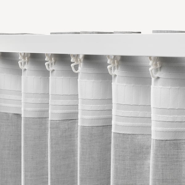 Rideaux à rayures blanches avec crochets pour suspendre, offrant intimité et contrôle de la lumière.