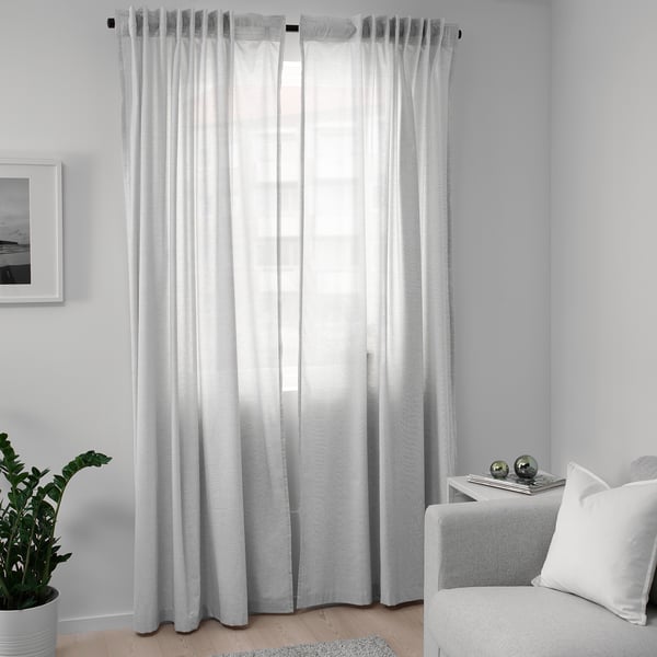 Rideaux transparents blancs à côté de la plante, de la chaise et de la fenêtre.