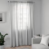 Rideaux transparents blancs à côté de la plante, de la chaise et de la fenêtre.