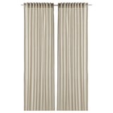 Deux rideaux en coton beige avec penderie passe-tringle, offrant intimité et filtrage de la lumière.