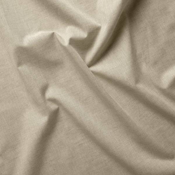 Tissu de rideau en coton beige ; lisse, légèrement froncé, montrant la texture et la qualité.