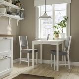 Coin cuisine avec table HAUGA, chaises, fenêtre, plante et ordinateur portable.