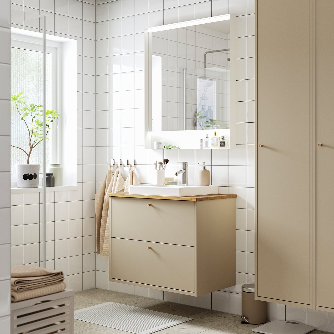 Armoire de salle de bain beige moderne avec lavabo, miroir et serviettes.