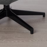 Pied de chaise de bureau noir sur plancher en bois. Conception robuste et polie.