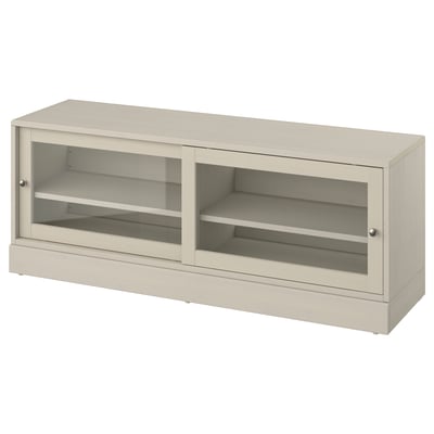 Le banc TV HAVSTA, beige clair, portes coulissantes en verre et bois de pin, offre un design à la fois rustique et moderne.