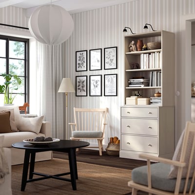 Salon moderne avec des meubles en bois clair. Coffre HAVSTA blanc, table basse noire, canapé beige, chaise en bois, rideaux légers.