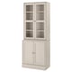 Élégante armoire HAVSTA beige clair avec portes en verre, pin massif, style rustique pour l’exposition des articles.