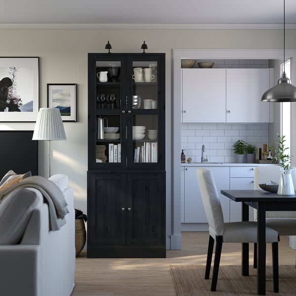 Salon/salle à manger confortable : armoire HAVSTA, livres. Canapé blanc, chaises, cuisine moderne, plante.