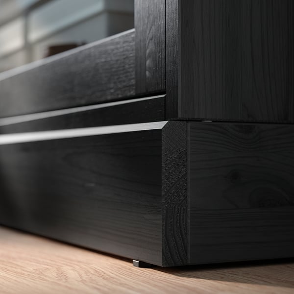 Coin meuble en bois noir aux lignes épurées. Finition foncée, surface lisse et détail de joint incliné.