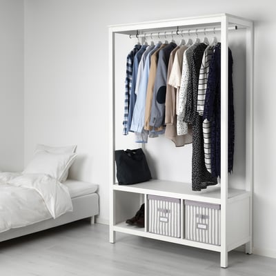 Armoire blanche HEMNES avec étagères en pin dans une chambre minimaliste, paniers en tissu.