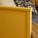 Structure en bois peinte en jaune vif avec des lattes verticales, montrant la qualité de l’artisanat et la finition propre.