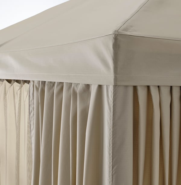 Gros plan d’un gazebo beige avec des coutures serrées et des rideaux plissés. Tissu de haute qualité et savoir-faire visibles.