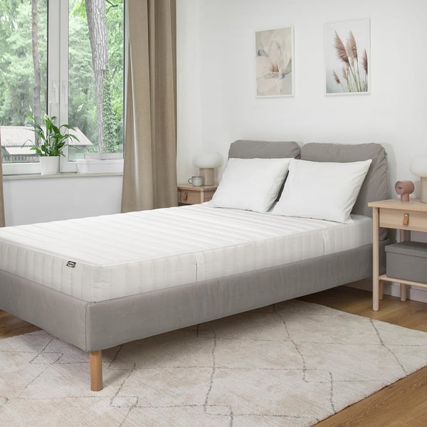 Chambre moderne avec lit blanc HÖJEHALL, tapis, art minimaliste et grande fenêtre.