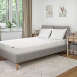 Chambre moderne avec lit blanc HÖJEHALL, tapis, art minimaliste et grande fenêtre.