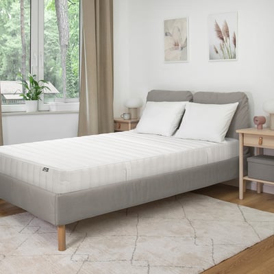 Chambre moderne avec lit blanc HÖJEHALL, tapis, art minimaliste et grande fenêtre.