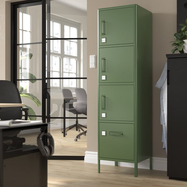 Armoire de rangement en métal vert avec plusieurs compartiments dans un bureau.
