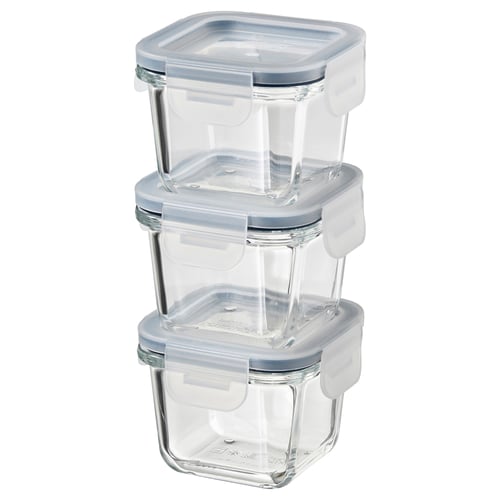 Trois récipients alimentaires carrés en verre transparent IKEA 365+ empilés avec des couvercles bleus, conçus pour stocker et réchauffer les aliments.