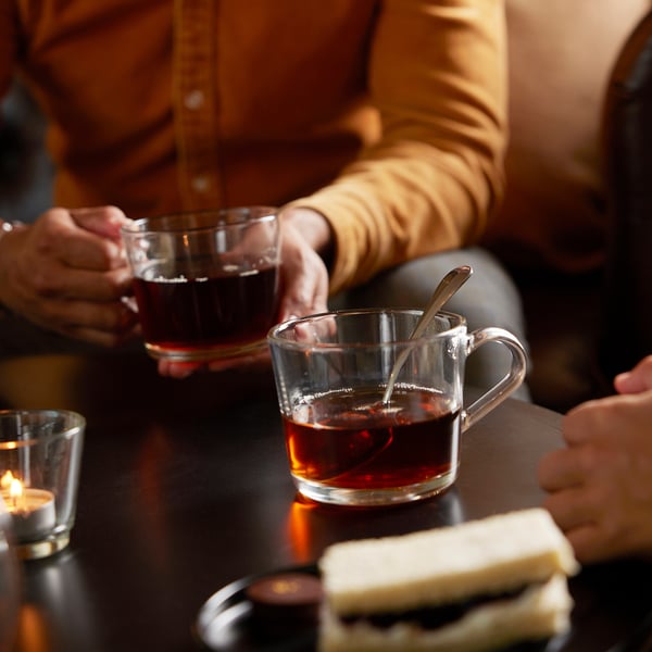 Deux personnes avec thé glacé et sandwich. Bougie allumée.