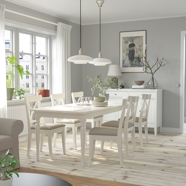 Salle à manger avec table INGATORP, de la verdure, des fleurs, deux lampes, et une grande fenêtre.