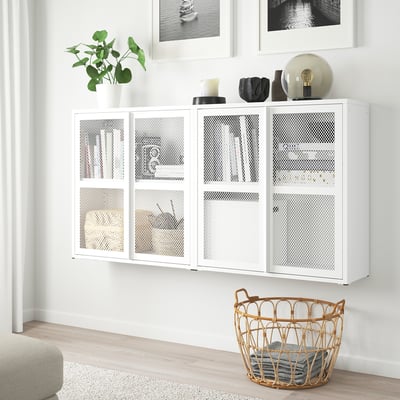Armoire en maille IVAR blanche, design moderne ; taille comparable à un cadre mural, contenant des décorations, une plante et un panier avec des serviettes.