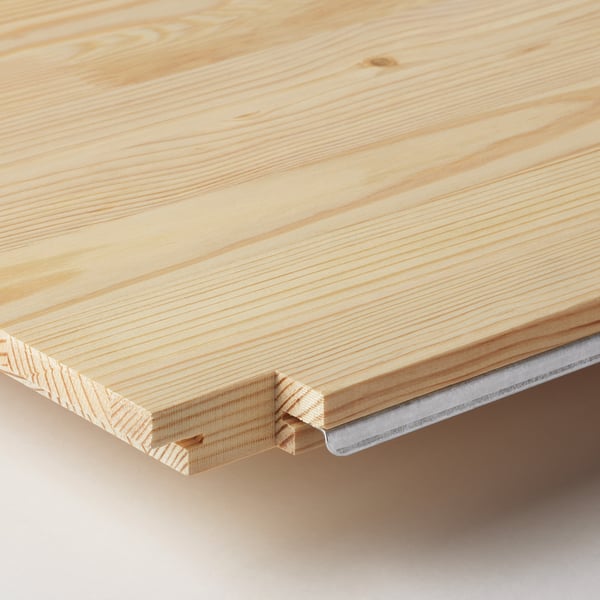 Gros plan sur une surface en bois lisse et léger, mettant en valeur le grain naturel et la qualité de l’artisanat.