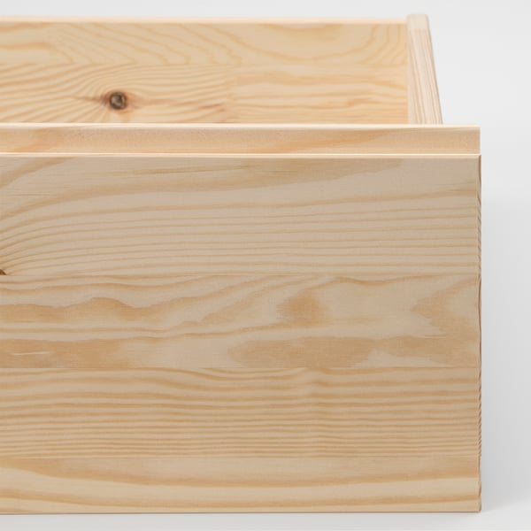 Gros plan d’un tiroir en bois de pin léger mais durable, mettant en valeur la texture naturelle du grain.