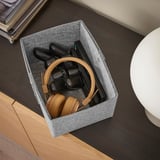 La boîte sur le bureau permet de ranger les écouteurs et les manettes.