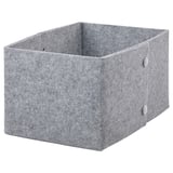 Une boîte de rangement en feutre JÄGMÄSTARE grise et rectangulaire avec des fixations métalliques, adaptée à l’organisation de divers articles.