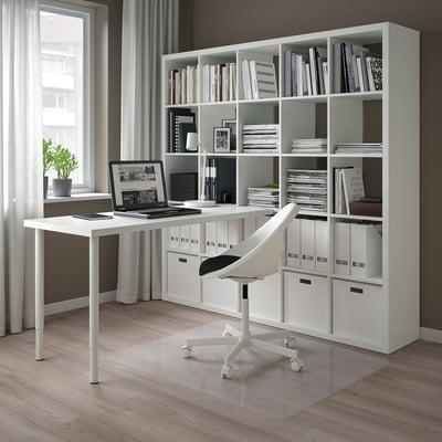 Bureau à domicile moderne avec rangement KALLAX, bureau, ordinateur portable, chaise et grande fenêtre.