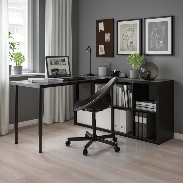 Configuration moderne du bureau à domicile avec étagère noire KALLAX, bureau, chaise, ordinateur portable et décoration. Murs gris, grande fenêtre.