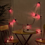 Les lumières rouges KASTTÅG décorent les petits espaces, drapant autour de la table avec du papier journal, créant une atmosphère chaleureuse.