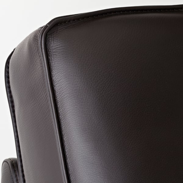 Chaise longue en cuir noir gros plan. Surface lisse et texturée avec des coutures soignées, mettant en valeur un savoir-faire de qualité.