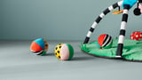 Jouets sphériques colorés sur tapis vert, tiges rayées.