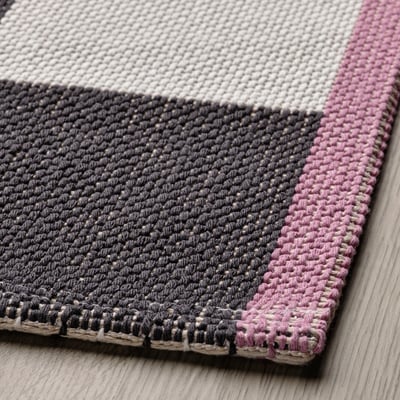 Tapis KLASSRUM : damier noir et blanc, côtés roses et jaunes, rectangulaire, coton tissé à plat et polypropylène.