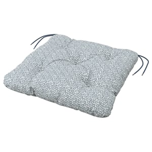 Un coussin KLÖSAN gris avec un motif floral, des bords noués et un matériau en polyester recyclé.