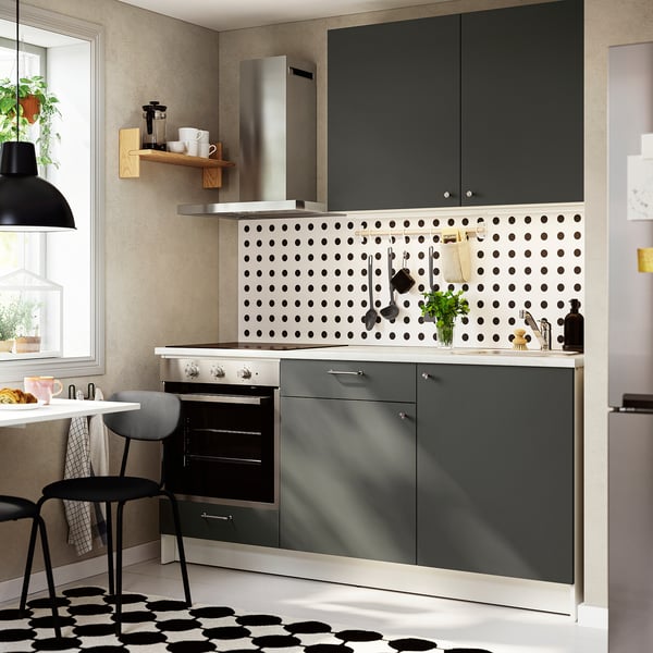 Ensemble de cuisine gris foncé KNOXHULT avec comptoir en marbre, design minimaliste sous suspension noire.