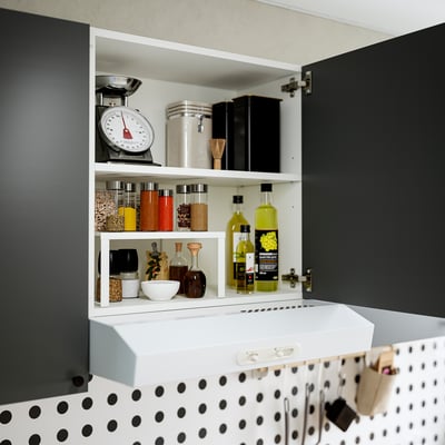 Armoire murale avec étagère réglable, rangeant des articles de cuisine comme des épices, des huiles et une balance.
