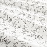 Drap de lit à motifs floraux, finement détaillé, doux, dans les tons noirs et blancs, avec de petites fleurs et des vignes, offrant un look romantique et rêveur.