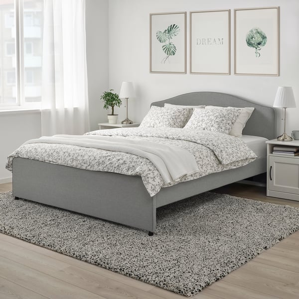 Ensemble de housse de couette florale grise, design romantique classique, sur lit avec tapis et tête de lit gris.