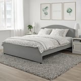 Ensemble de housse de couette florale grise, design romantique classique, sur lit avec tapis et tête de lit gris.