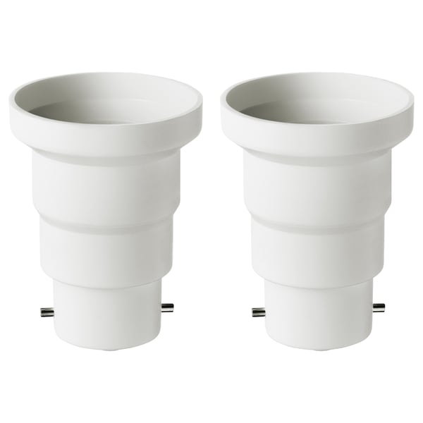 Deux adaptateurs KOPPLA en plastique blanc convertissent les douilles b22 en e27, cylindriques avec un design lisse.