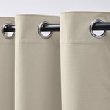 Rideaux beiges avec œillets pour une suspension facile, bloquant la lumière et offrant de l’intimité.