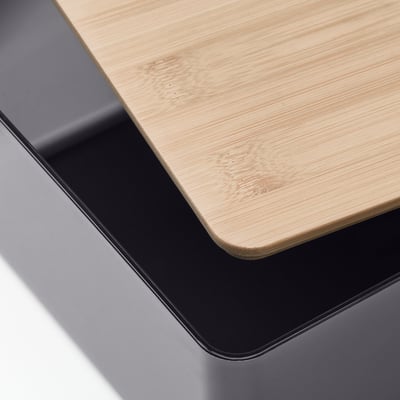 Gros plan d’une boîte en bois avec une bordure noire élégante, mettant en valeur sa finition naturelle et lisse.
